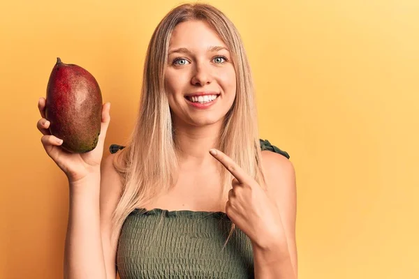 Mango Tutan Genç Güzel Sarışın Kız Gülümsüyor — Stok fotoğraf