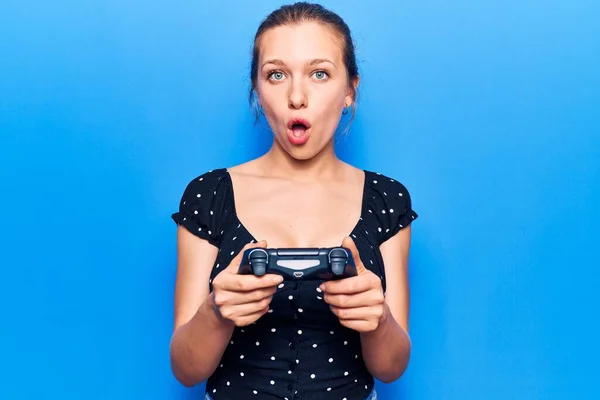 Joven Rubia Jugando Videojuego Sosteniendo Controlador Asustado Sorprendido Con Boca — Foto de Stock