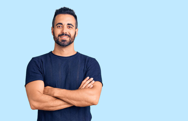 Young hispanic man wearing casual clothes happy face smiling with crossed arms looking at the camera. positive person. 