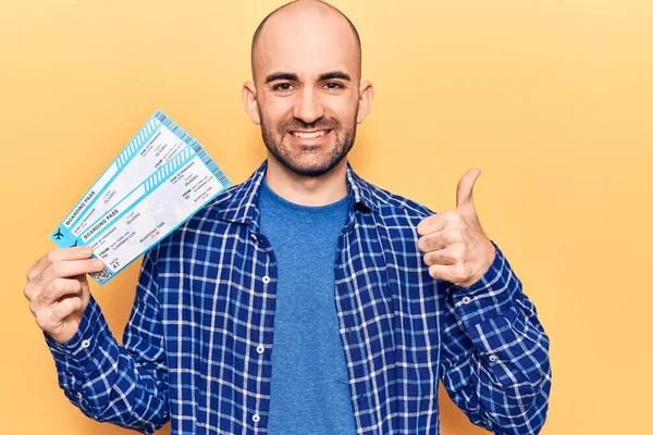 Joven Hombre Calvo Guapo Sosteniendo Tarjeta Embarque Aerolínea Sonriendo Feliz —  Fotos de Stock