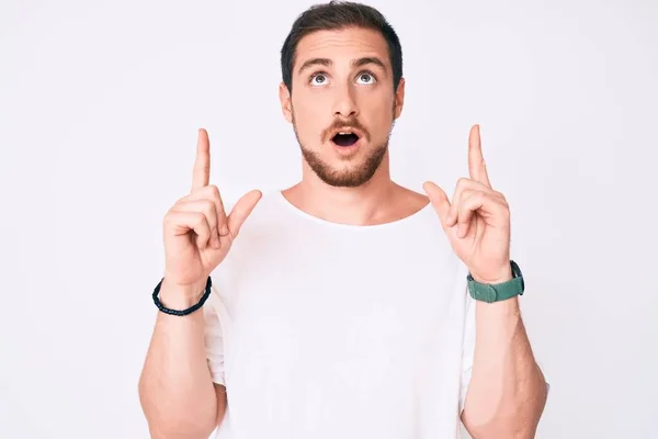 Young Handsome Man Wearing Casual White Tshirt Amazed Surprised Looking — Stock Photo, Image