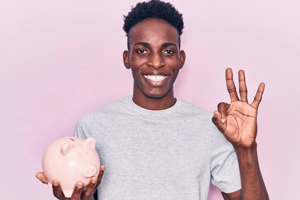 Jonge Afro Amerikaanse Man Houdt Spaarvarken Bank Doet Teken Met — Stockfoto