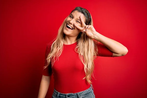 Jovem Mulher Loira Bonita Vestindo Camiseta Casual Sobre Fundo Vermelho — Fotografia de Stock