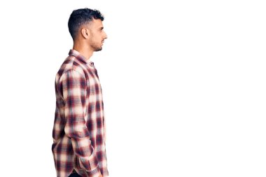 Latin kökenli genç adam rahat bir görünüm takınıyor, rahat bir görünüm takınıyor, kendine güvenen bir gülümsemeyle.. 