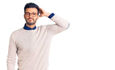 Zarif kıyafetler ve gözlük takan genç, yakışıklı İspanyol adam soru sormayı ve kafasını karıştırıyor. Şüpheyle kararsız, kafa kafaya düşünerek. Düşünceli kavram. 