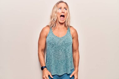 Orta yaşlı beyaz kadın spor kıyafetleri giyiyor kızgın ve kızgın çığlık atıyor sinirli ve öfkeli, öfkeyle bağırıyor. öfke ve agresif konsept. 