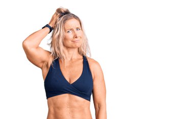 Orta yaşlı, sarışın, bikini giyen bir kadın. Şüpheyle kararsız, kafa kafaya düşünerek. Düşünceli kavram. 