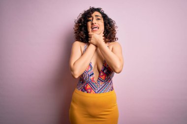 Genç, güzel bir Arap kadın, mayo ve pembe arka planda güneş gözlüğü takarak tatilde. Boğularak ölsün diye bağırıyor. Sağlık problemi. Boğulma ve intihar konsepti.