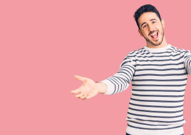 Gündelik kıyafetler giyen, neşeli gülümseyen, yardım eli uzatan ve kabullenen genç İspanyol adam.. 