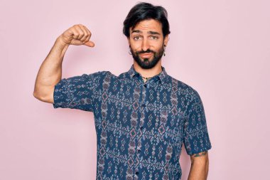 Pembe arka planda hippi tarzı giyinmiş genç, İspanyol bohem bir adam. Güçlü, güçlü, kendinden emin ve gururlu biri.