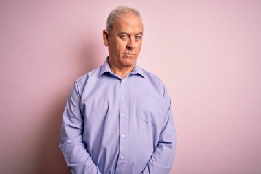 Orta yaşlı yakışıklı, beyaz gömlekli, pembe arka planda duran, kuşkucu ve gergin, sorun yüzünden surat asan bir adam. Negatif kişi.