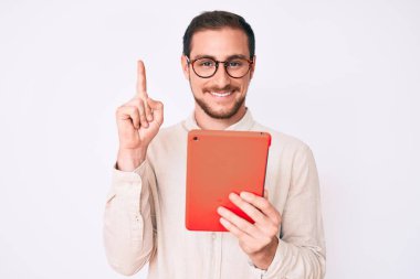 Dokunmatik ped kullanan genç yakışıklı bir adam bir fikre ya da soru işaretine şaşırdı ve mutlu bir yüzle işaret etti. 