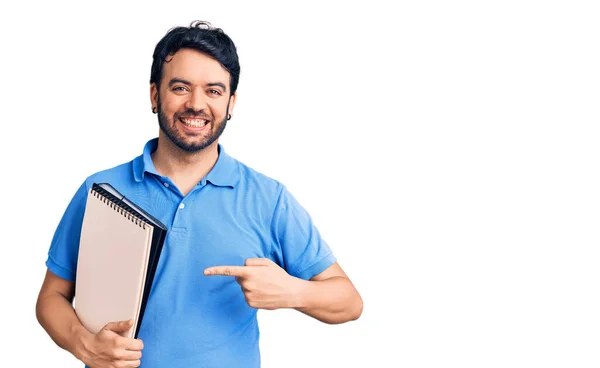 Jeune Homme Hispanique Tenant Cahier Souriant Heureux Pointant Avec Main — Photo