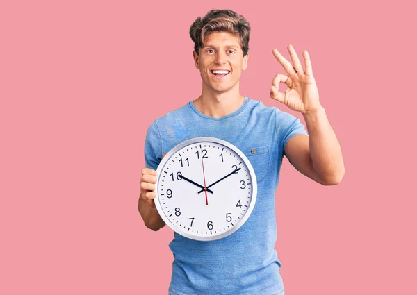 Joven Hombre Guapo Sosteniendo Gran Reloj Haciendo Signo Con Los — Foto de Stock