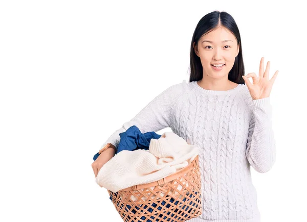 Młoda Piękna Chinka Trzyma Kosz Pranie Ubraniami Robi Znak Palcami — Zdjęcie stockowe