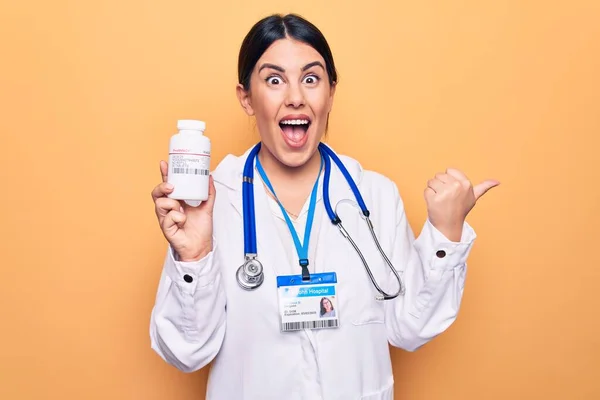 Giovane Donna Medico Indossando Stetoscopio Bottiglia Pillole Sfondo Giallo Puntando — Foto Stock