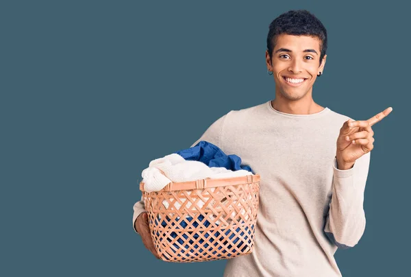 Joven Hombre Amerciano Africano Sosteniendo Cesta Ropa Sonriendo Feliz Señalando — Foto de Stock