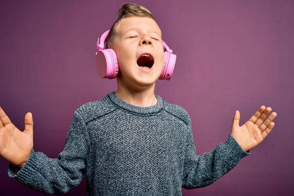 Mladý Malý Běloch Nosí Sluchátka Poslouchá Hudbu Purpurovém Pozadí Oslavuje — Stock fotografie