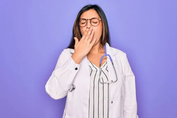직업적 의사인 여자가 청진기를 보라색 의상을 피로에 지친입을 손으로 가렸다 — 스톡 사진