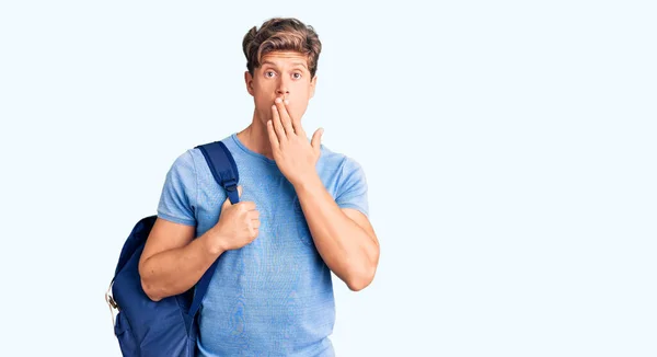 Jovem Homem Bonito Segurando Mochila Estudantil Cobrindo Boca Com Mão — Fotografia de Stock