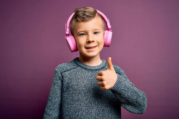 Маленький Белый Мальчик Наушниках Слушает Музыку Фиолетовом Фоне Делает Счастливый — стоковое фото