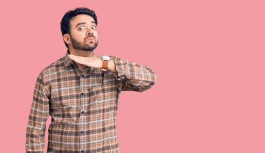 Gündelik kıyafetler giyen, boğazını bıçak niyetine kesen, saldırganlığı şiddetle tehdit eden genç İspanyol bir adam. 