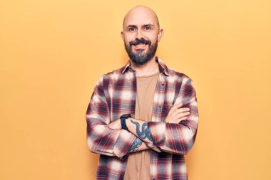 Sıradan kıyafetler giyen, kollarını kavuşturup kameraya bakan mutlu yüzlü genç bir adam. pozitif kişi. 