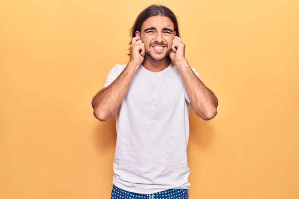 Ung Stilig Man Klädd Avslappnade Kläder Täcker Öronen Med Fingrar — Stockfoto