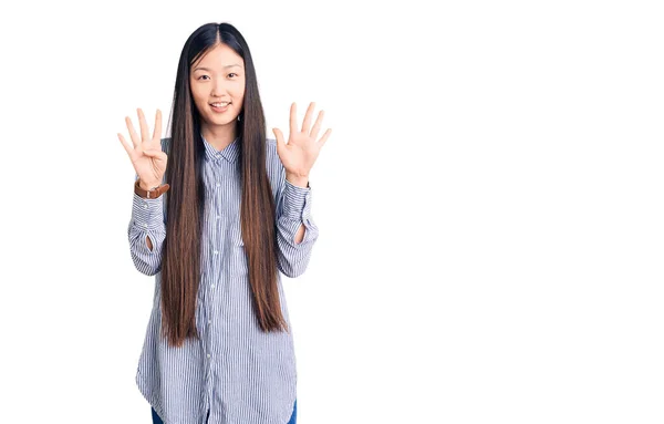 年轻美丽的中国女人 身穿休闲装 手指头指九号 面带微笑 自信而快乐 — 图库照片
