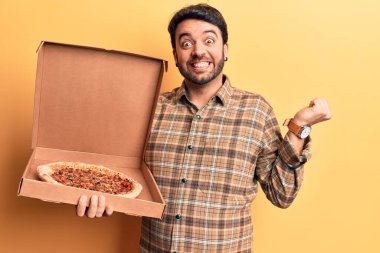 İspanyol asıllı genç elinde pizza kutusu tutuyordu. Gururla bağırıyordu. Zaferi kutluyordu ve başarıyı kutluyordu. 