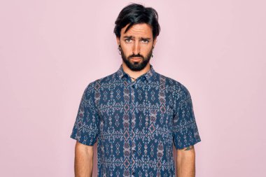 Pembe arka planda hippi tarzı giyinen genç, yakışıklı bohem adam depresif ve sıkıntılı, sinirli ve korkmuş. Üzücü ifade.