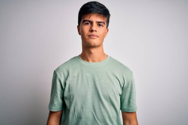 Young handsome man wearing casual t-shirt standing over isolated white background with serious expression on face. Simple and natural looking at the camera.