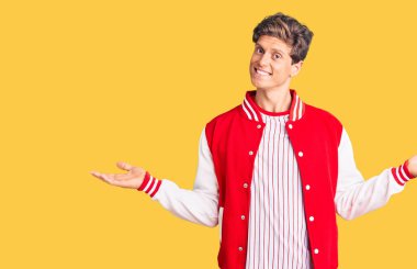 Beyzbol üniforması giyen genç yakışıklı adam gülümsüyor. İki elini de açık tutuyor. Karşılaştırma ve reklam karşılaştırması yapıyor ve dengeyi sağlıyor. 