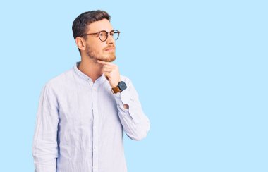 Zarif iş gömleği giyen, gözlüklü, boynu ağrıyan, boğazı ağrıyan, grip, mantar ve enfeksiyon kapmış yakışıklı bir genç. 