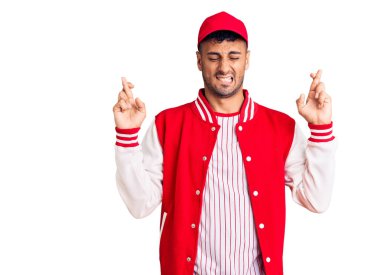 Beyzbol forması giyen genç İspanyol adam umut ve gözlerin kapalı gülümseyerek bana işaret ediyor. Şans ve batıl inançlar. 