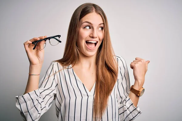 Młoda Piękna Ruda Optyczna Kobieta Trzyma Okulary Białym Tle Wskazując — Zdjęcie stockowe