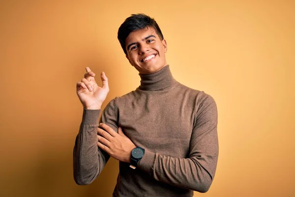 터틀넥 스웨터를 손가락으로 카메라를 바라보며 웃음을 잘생긴 — 스톡 사진