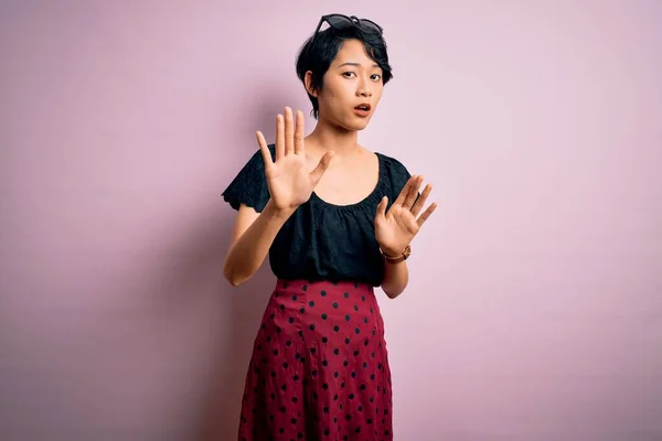 年轻美丽的亚洲女孩穿着休闲装 站在孤立的粉色背景之上手心移开 带着恐惧和厌恶的表情表示拒绝和否认 停止和禁止 — 图库照片