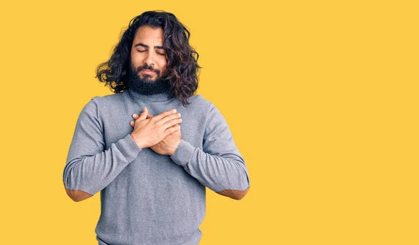 年轻的阿拉伯男子身穿休闲装 双手胸前挂着微笑 闭着眼睛 脸上挂着感激的手势 健康概念 — 图库照片