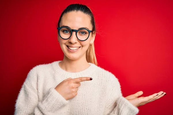 Piękna Blondynka Niebieskimi Oczami Swetrze Okularach Czerwonym Tle Zdumiona Uśmiechnięta — Zdjęcie stockowe