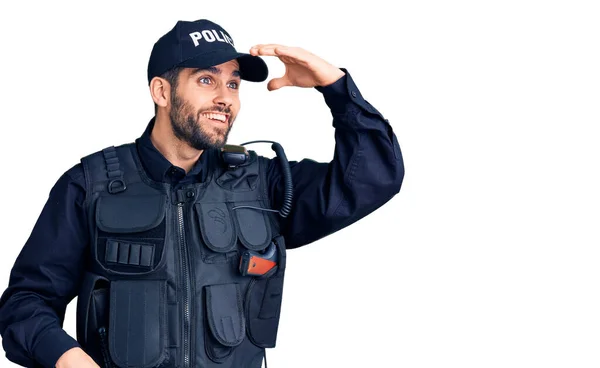 髭を生やした若いハンサムな男は 警察の制服を非常に幸せと笑みを浮かべて遠くに手を頭の上に見ている 検索の概念 — ストック写真