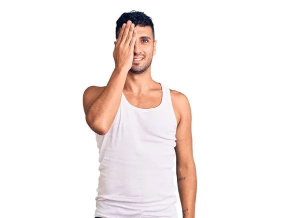 Mladý Hispánec Neformálním Oblečení Zakrývajícím Jedno Oko Rukou Sebevědomý Úsměv — Stock fotografie
