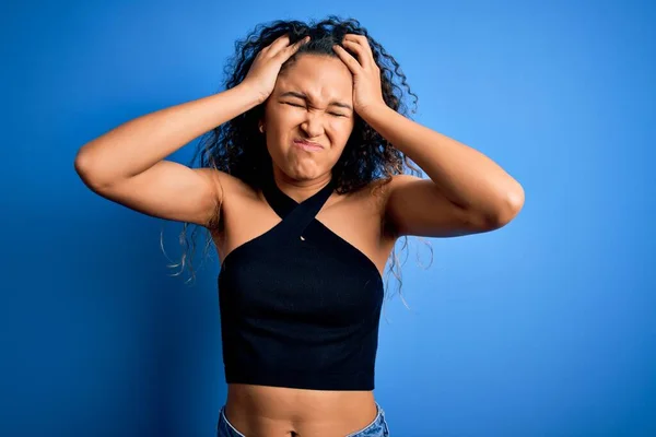 Kıvırcık Saçlı Sıradan Tişörtlü Genç Bir Kadın Mavi Arka Planda — Stok fotoğraf