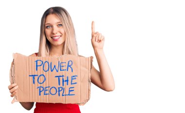 Genç ve güzel sarışın bir kadın elinde güç taşırken bir fikir ya da soruyla şaşkın bir şekilde mutlu bir yüzü işaret ediyor. 