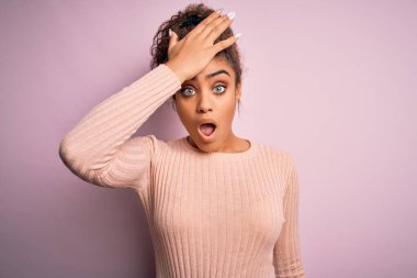 Güzel, Afro-Amerikan bir genç kız pembe arka plan üzerinde gelişigüzel bir süveter giyiyor. Hatayla el ele tutuşup şaşırmış. Hatayı hatırla. Unuttum, kötü hafıza konsepti.