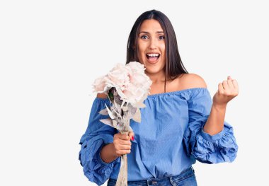 Genç, güzel esmer kadın elinde buketle gururla bağırıyor zaferi ve başarıyı kutluyor. 