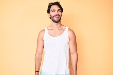 Yakışıklı, İspanyol bakışlı, güneş gözlüklü, gülümseyen bir adam.. 