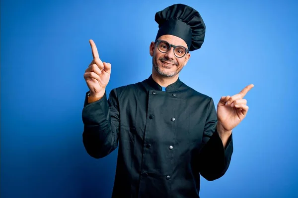 Mladý Pohledný Kuchař Kuchařské Uniformě Klobouku Izolovaném Modrém Pozadí Usmívající — Stock fotografie
