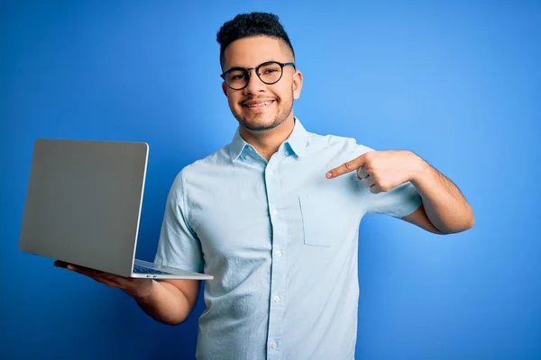Fiatal Jóképű Üzletember Szemüveget Visel Laptopot Használ Kék Háttér Felett — Stock Fotó