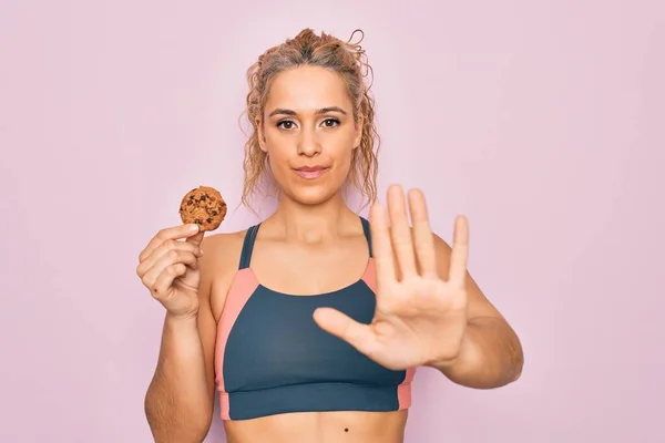 Joven Hermosa Rubia Deportista Haciendo Deporte Celebración Cookies Sobre Fondo — Foto de Stock